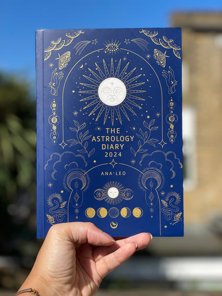 Um livro azul escuro com um Sol na capa